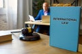 Lawyer holds INTERNATIONAL LAW book. TheÃÂ international lawÃÂ is enshrined in conventions, treaties and standards